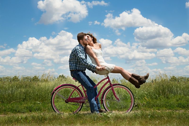 彼氏が運転する自転車に彼女を乗せて幸せそうに走っている