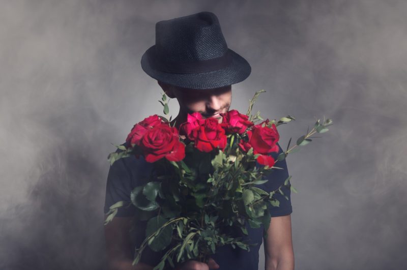 バラの花束を持つ男性